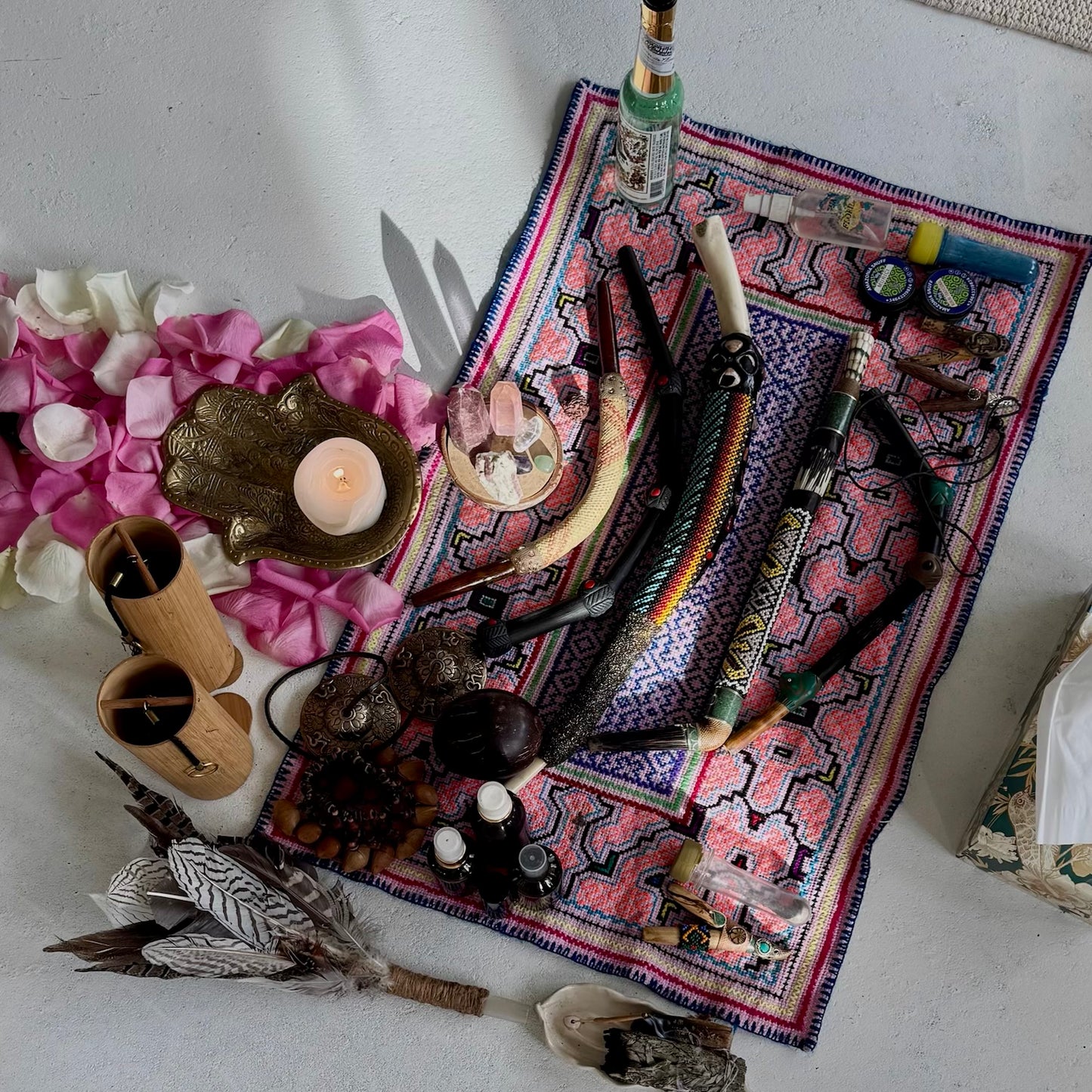 Various objects including candles, feathers, Tepi applicator for rapeh and shipibo altar cloth
