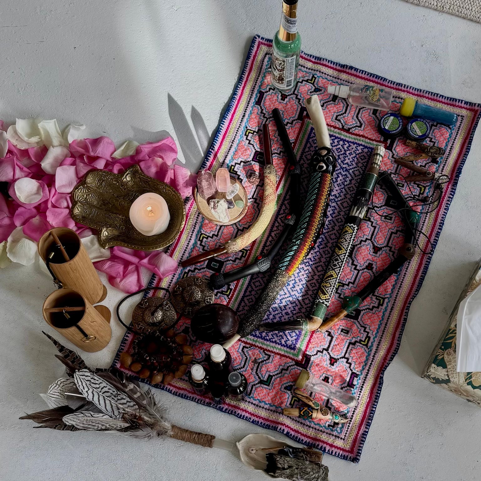 Various objects including candles, feathers, Tepi applicator for rapeh and shipibo altar cloth